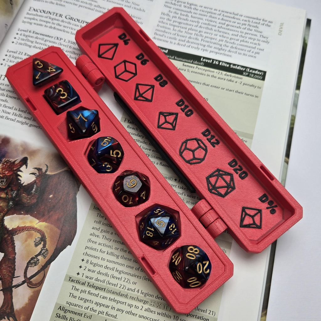 Red dice tray with black and gold polyhedral dice on top of a fantasy-themed book.