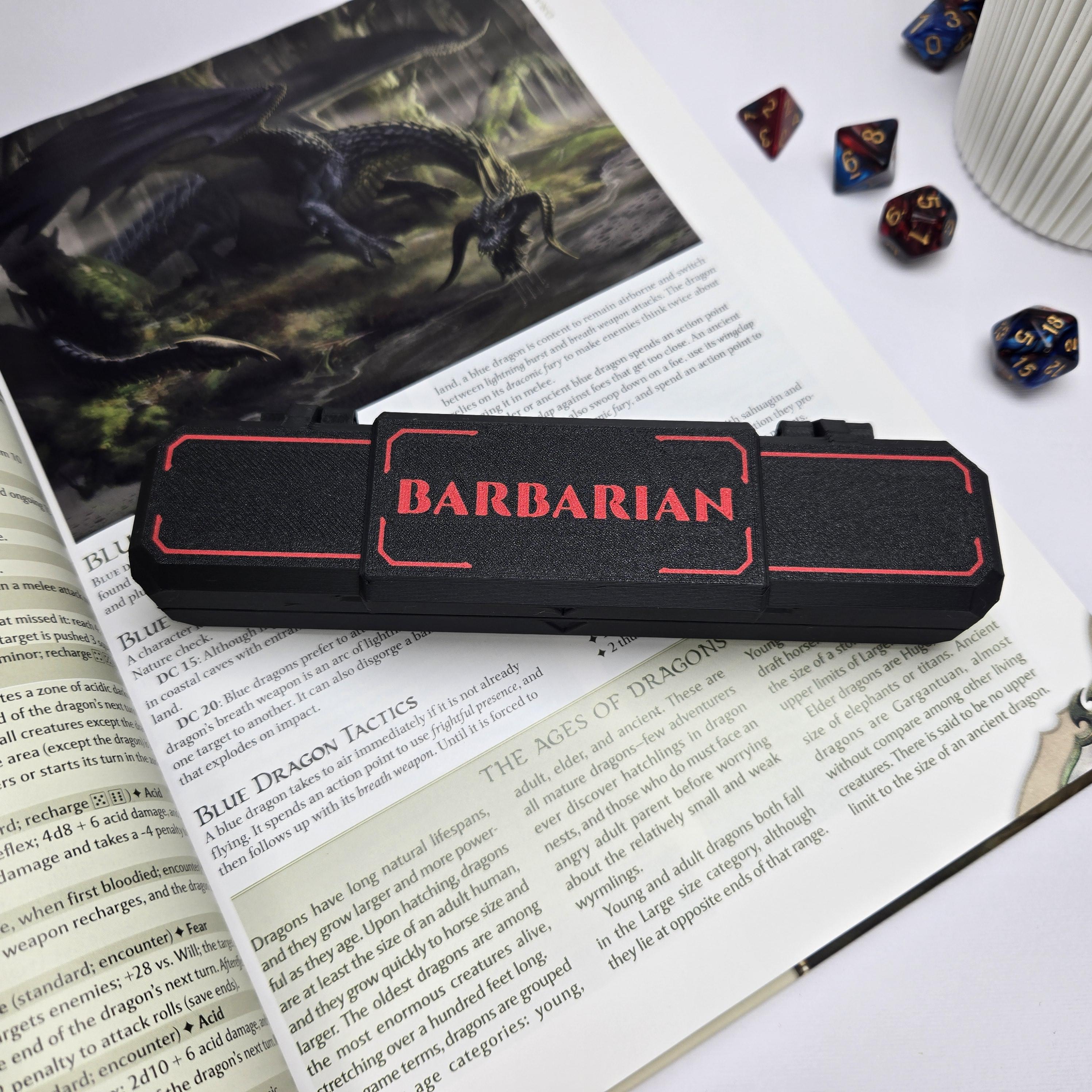 Black and red 'Barbarian' case on top of a book with game-related items around